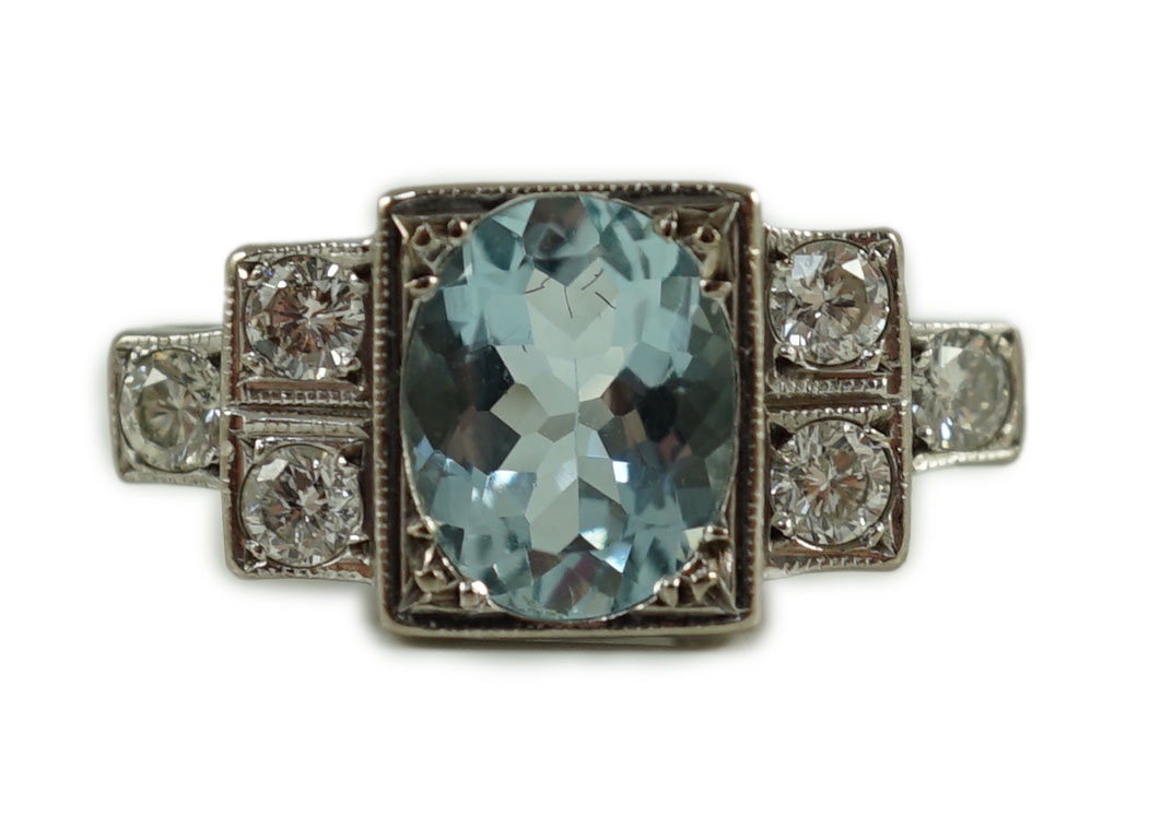 An 18ct white gold oval cut aquamarine and six stone diamond cluster set dress ring